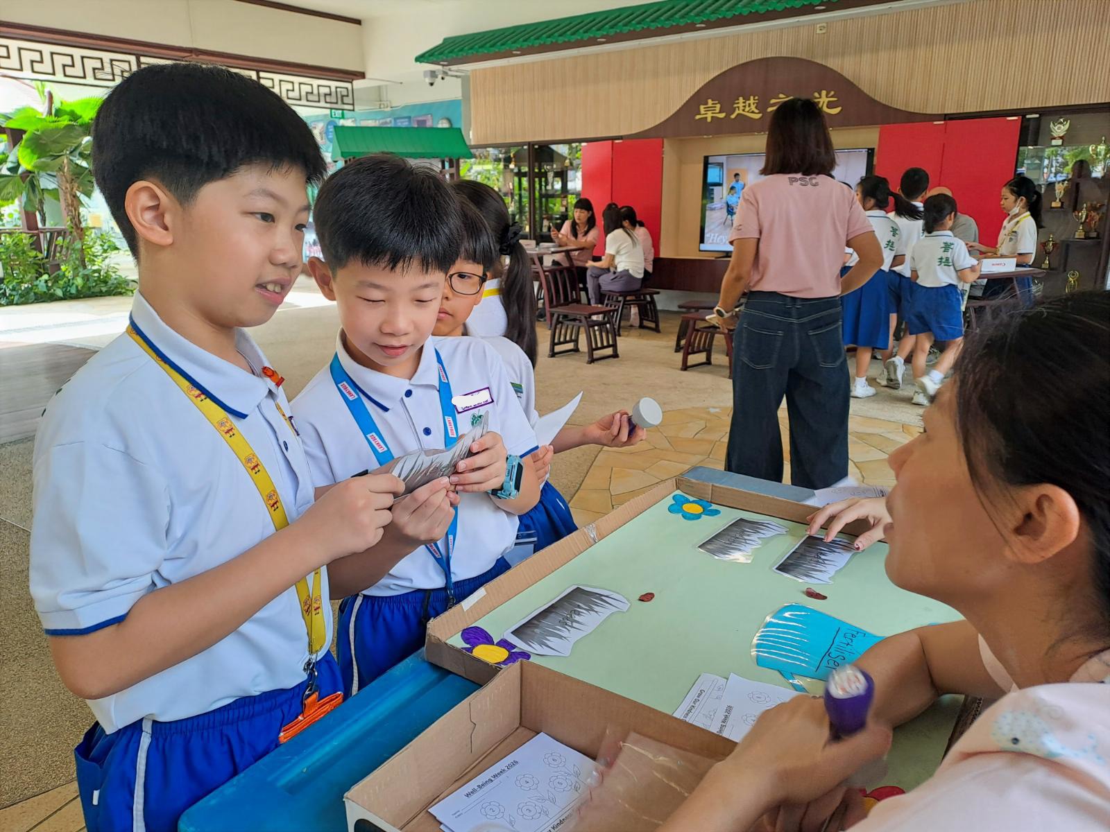 Pupils playing game during recess at school courtyard guided by parent volunteer