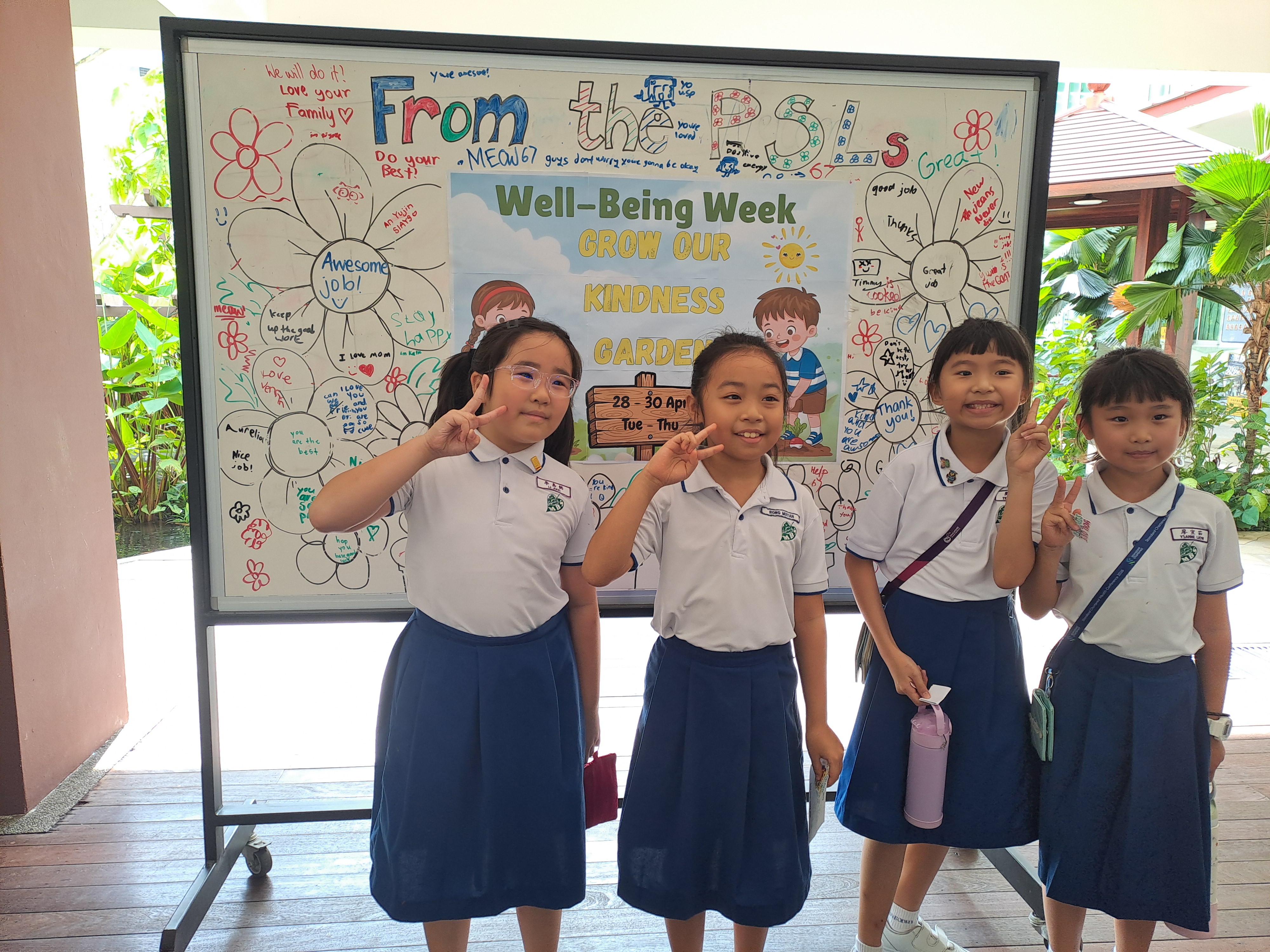 Pupils smiling in front of poster they designed