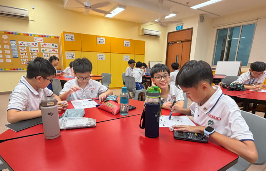 4 boys in PE attire doing group work during E2K