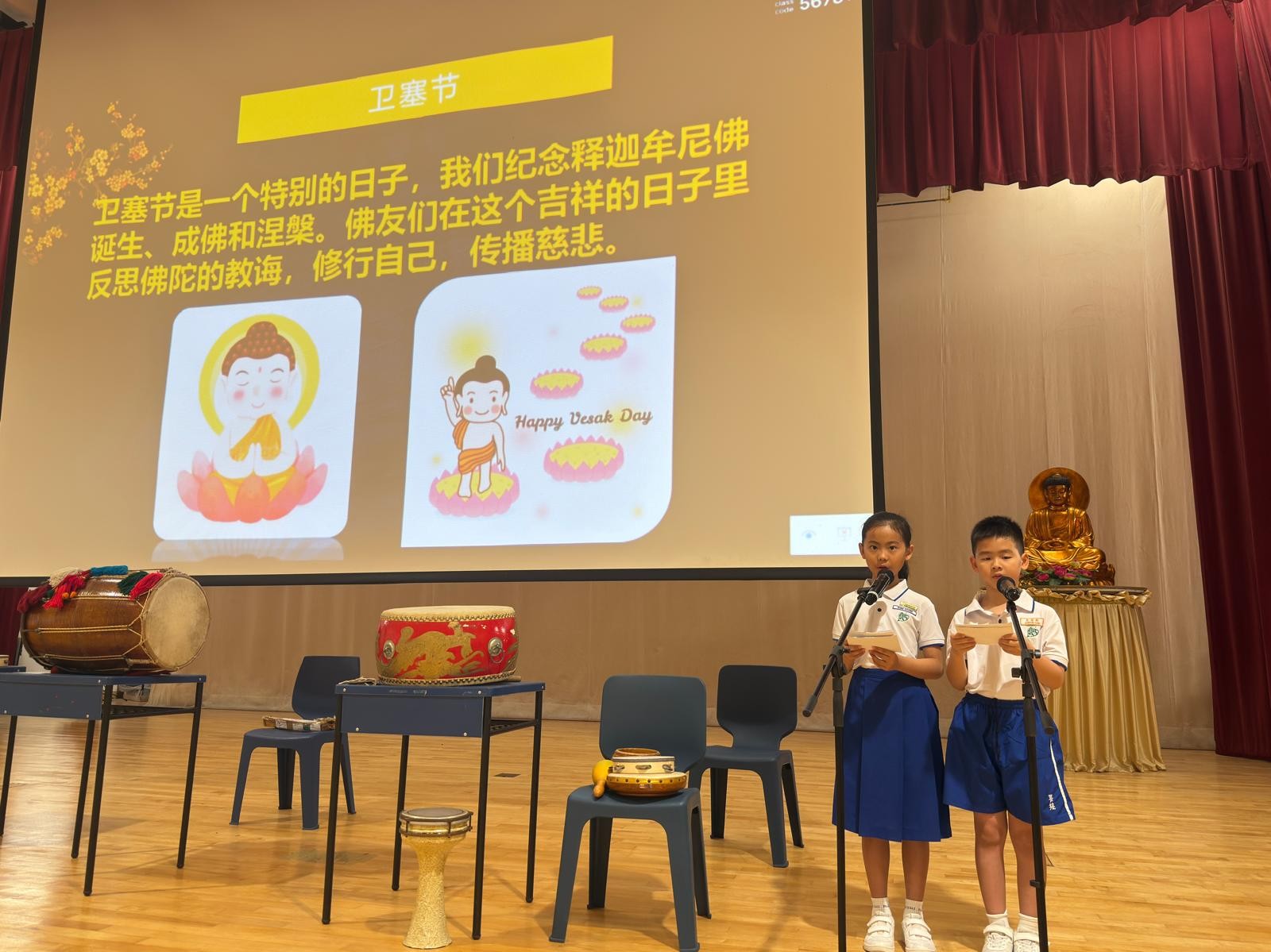 Pupils from Bodhi DNA group sharing about Vesak Day on stage in the hall