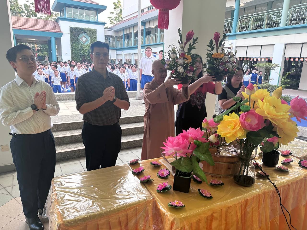 Venerable Seck Kwang Phing and Principal Mrs See Lai Kwan offering flowers to Buddha